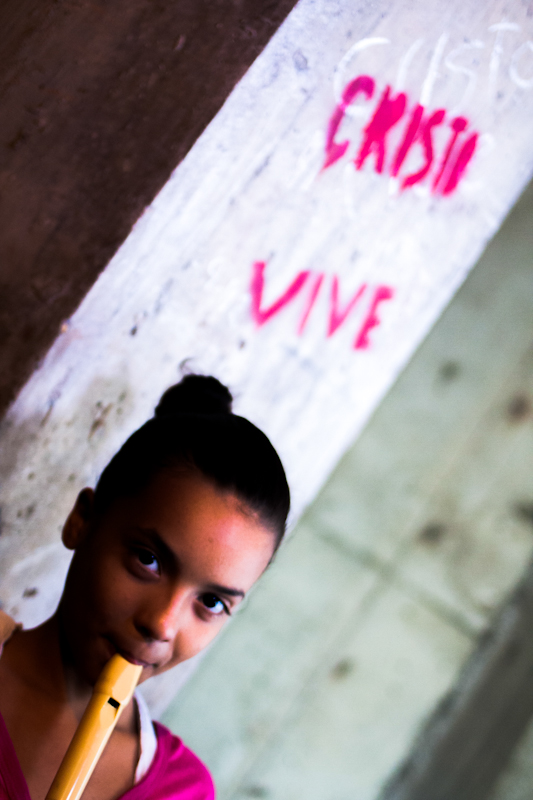 Una niña toca su flauta mientras se desenvuelve el desalojo de la Torre de David