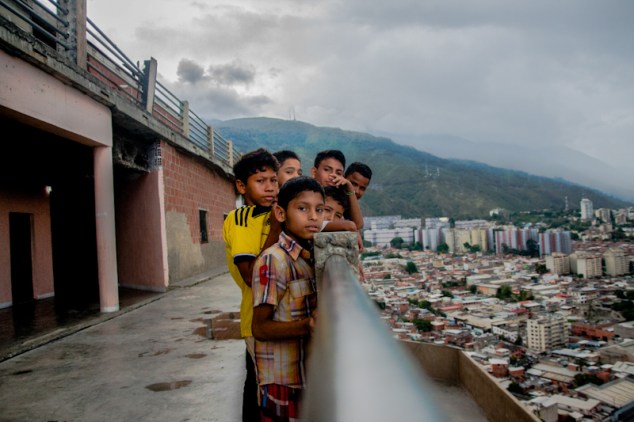 Niños juegan y posan en la baranda del piso 27 de la Torre de David