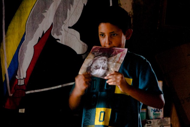 Un niño juega con un billete gigante mientras espera la hora de desalojar la Torre de David